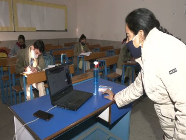 A teacher taking classes in hybrid mode in Delhi's National Victor Public School. (ANI/photo)