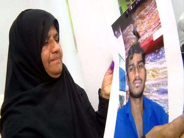 A mother in Hyderabad holding photo of his son stranded in Bangladesh. 