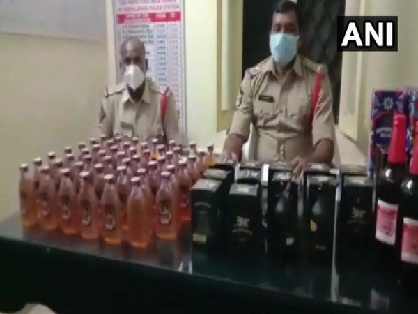 The Andhra Pradesh Police with the liquor bottles that were seized. Photo/ANI