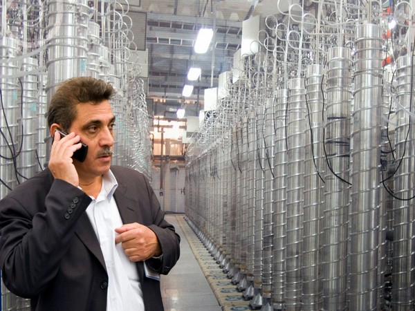 An official from Iran's Atomic Energy Organization speaks on his mobile phone in front of uranium enriching centrifuges. (Image credit: Reuters) 