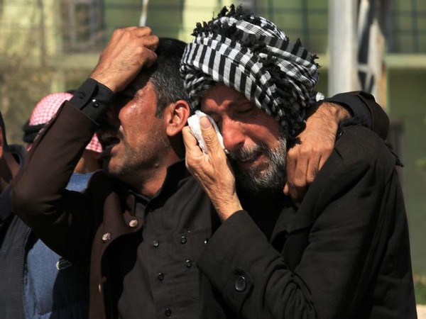 Relatives of the deceased mourn outside a mosque in Mosul, Iraq, on March 22