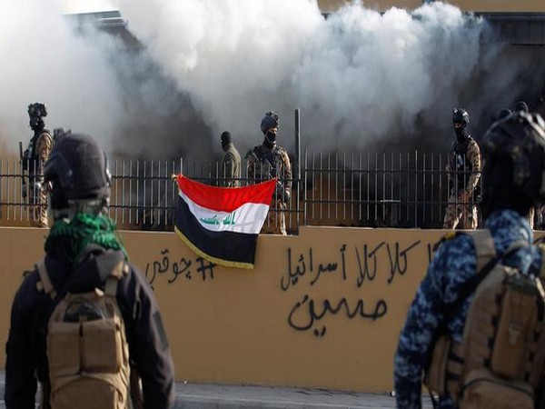 Members of Iraqi security forces are seen in front of the US Embassy during a protest to condemn airstrikes in Syria and Iraq.