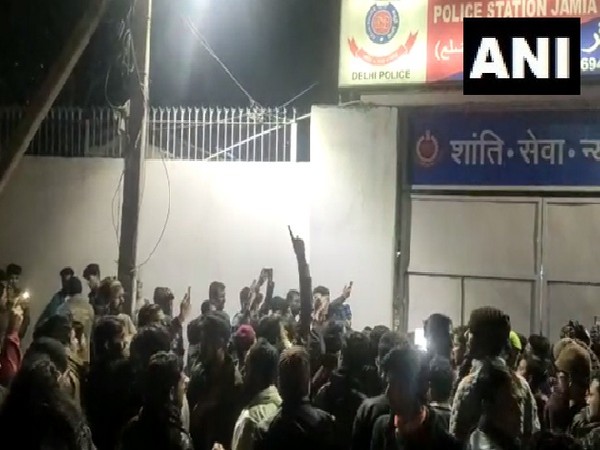 People gather outside Jamia Nagar police station in New Delhi following firing near the university.