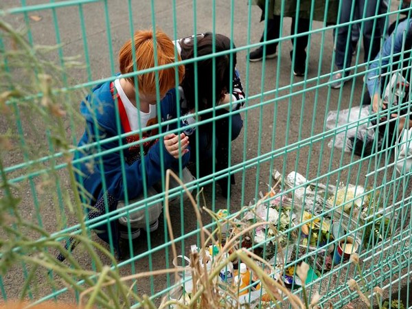 Local residents pray to mourn victims at the site of mass stabbing in Kawasaki, Japan on Tuesday. (Photo courtesy: Reuters)