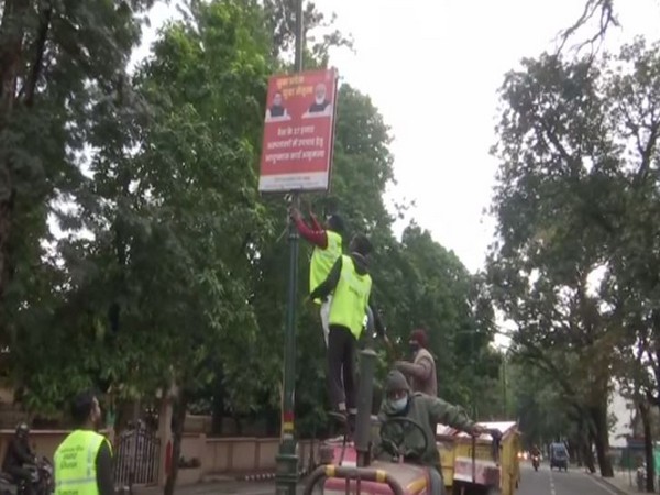 A hoarding being removed in Dehradun. (ANI/photo)