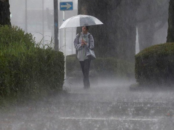 A pedestrian walks through the heavy rain in Kagoshima (Photo/Reuters)