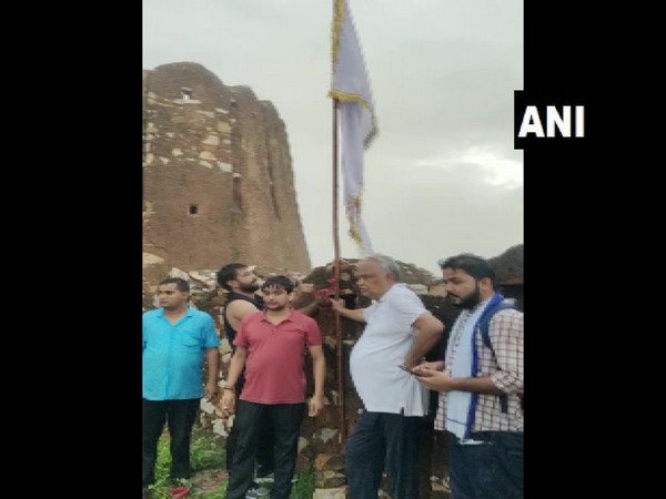 Kirodi Lal Meena standing with the flag at Amagarh Fort in Jaipur, Rajasthan.