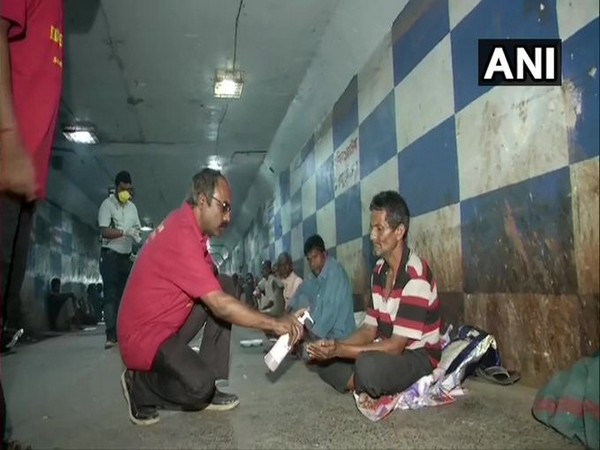ocial workers distributed food to destitute people who have taken shelter at underpass of Dum Dum railway station [Photo/ANI]