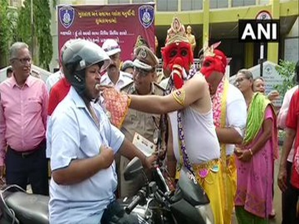 Traffic police offering laddus to bike riders wearing helmet at Rajkot 