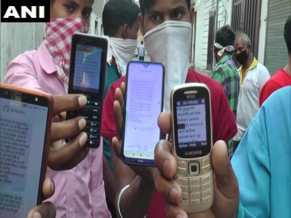 Migrant workers showing the message, they received after registering to go back to their native homes in Uttar Pradesh (Photo/ANI)