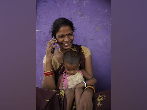 A woman listens to an mMitra calls on her phone in Nala Sopara, Mumbai