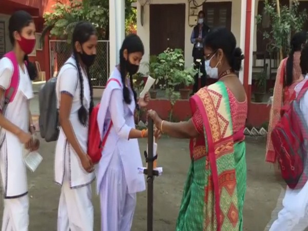Examinees at Siliguri Girls' High School sanitising hands before entering exam venue. (Photo/ANI)