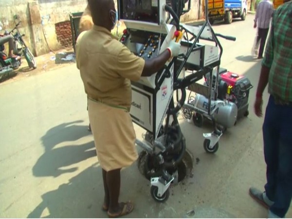 A Coimbatore municipal corporation worker uses robot to clean clogged drains [Photo/ANI]