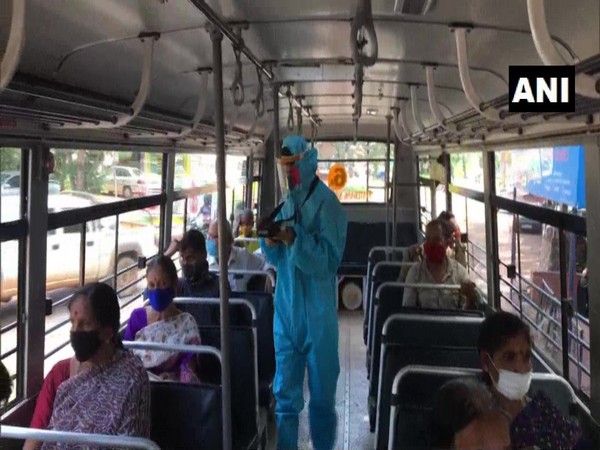 A private bus conductor was seen wearing a PPE kit while working in Mangaluru district. (Photo/ANI)