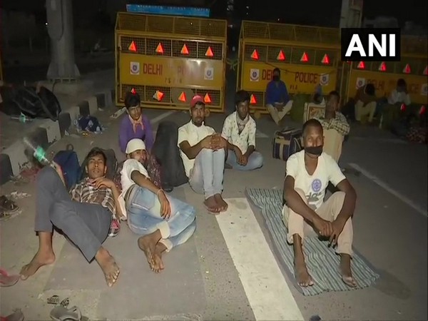 A group of migrant workers at a police barricade at Delhi-UP border 