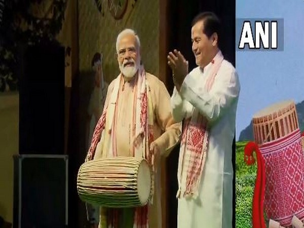 PM Narendra Modi with Sarbananda Sonowal playing dholak during the Bihu celebration. (ANI/photo)
