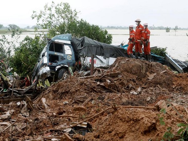 Rescue workers stand at the site of a landslide in Mon state, Myanmar on Aug 11 (Photo.Reuters)