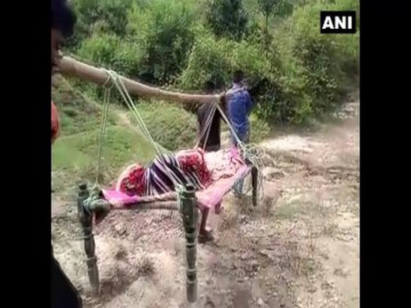 Sick woman carried on a cot suspended from a bamboo stick in Madhya Pradesh. 