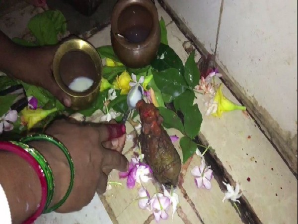 Devotees offering milk to idol of Nandi in Gaya, Bihar.