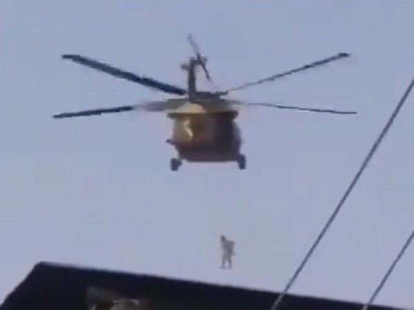Screengrab of a video showing the Taliban flying a US Black Hawk chopper with a body hanging from it.