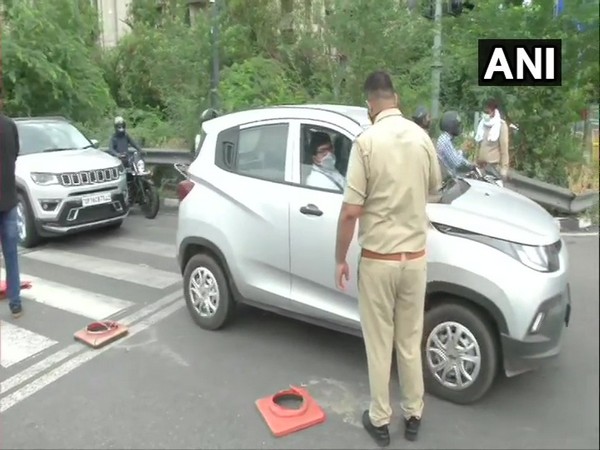 Police personnel checking IDs of commuters near Noida-Delhi border.