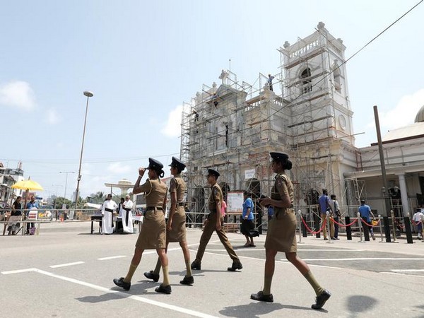 Sri Lankan police officers walk near the St. Anthony church, which was severely damaged in the Sri Lanka serial blasts last month