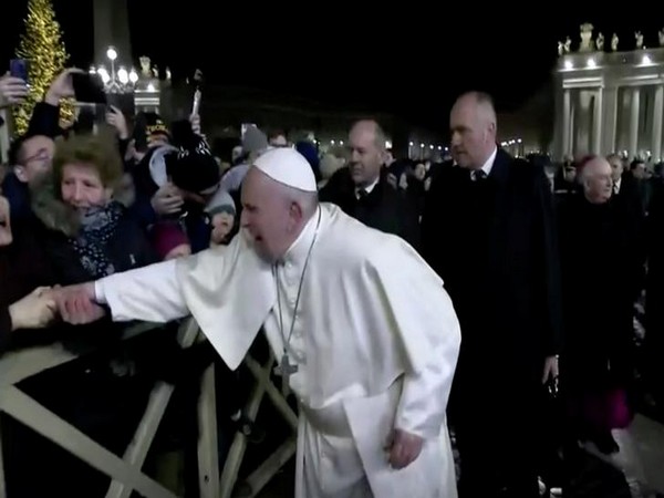 A woman grabs Pope Francis' hand and yanks him towards her, at Saint Peter's Square at the Vatican.