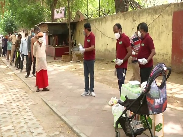 NGO members distributing food, essential items among poor in Delhi on Friday. Photo/ANI