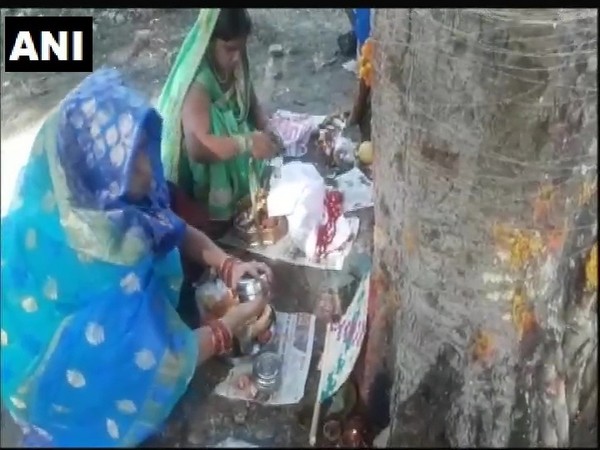 Women performing rituals for the pooja in Prayagraj, Uttar Pradesh.