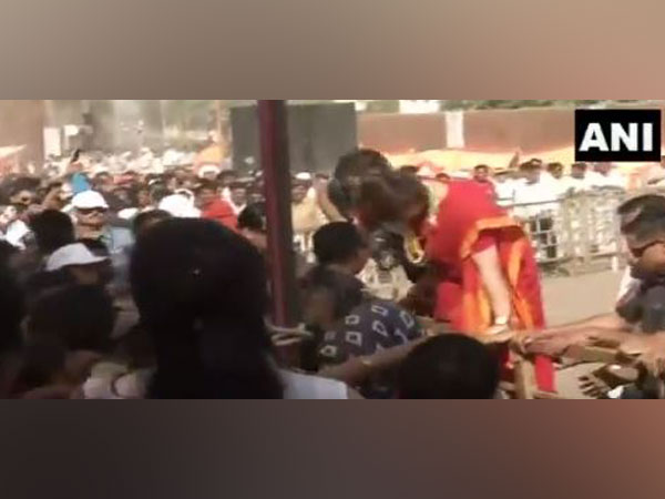 Congress general secretary Priyanka Gandhi climbs over a barricade in Ratlam