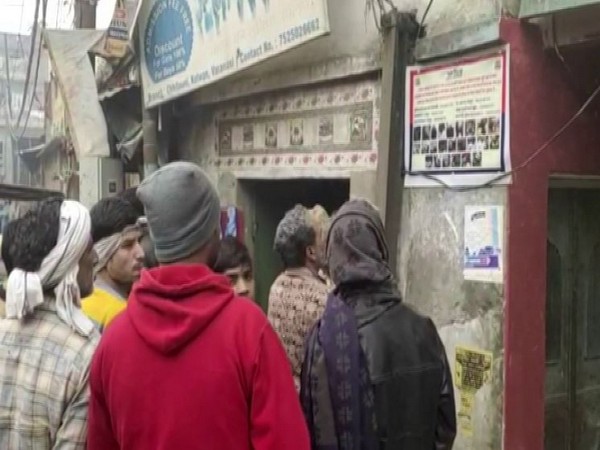 Locals in Varanasi carefully looking at the poster having the photographs of protsters who fanned violence on December 20 [Photo/ANI]