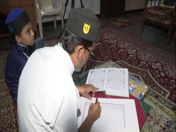 Mohammed Afzal copies the Quran in his handwriting. (Photo/ANI)I