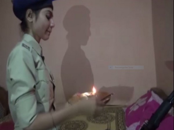 Kavita Kaushal ties a rakhi to her brother's rifle in Dantewada. Photo/ANI 