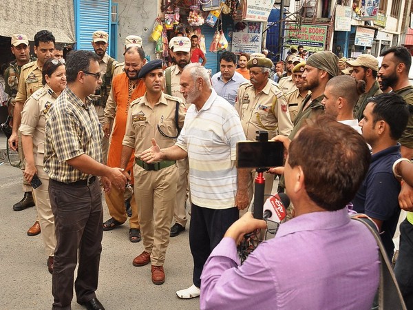 Local authorities interacting with people in Srinagar.