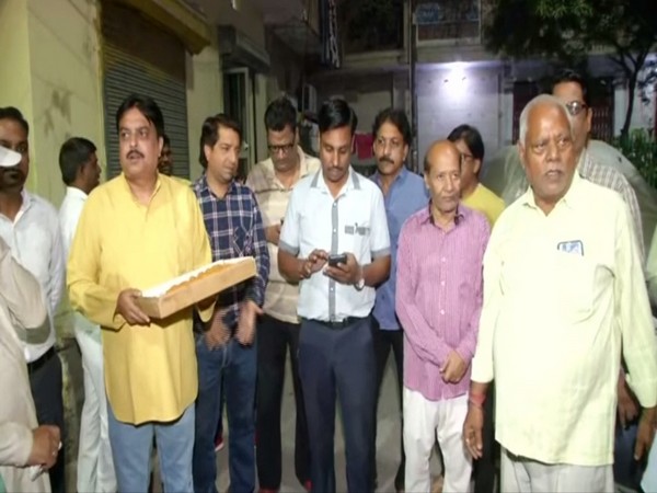 Residents of unauthorised colonies in Delhi distributing sweets on Wednesday. Photo/ANI