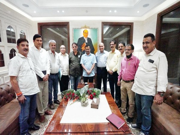 Delhi CM Arvind Kejriwal with Kashmiri Pandits at his residence. (ANI/photo)