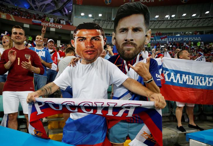 Fans supporting Messi and Ronaldo in the stadium. 