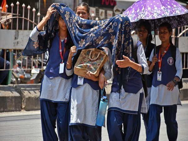 Students use umbrellas and scarves to protect themselves from heat in Ranchi. [File Photo/ANI}