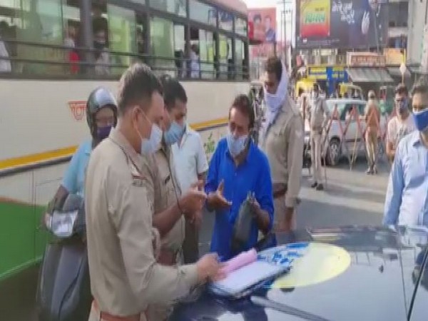 Policemen issue challan to a commuter for violating COVID-19 norms in Meerut on Monday. (Photo: ANI)
