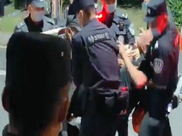 A protester being violently arrested by Chinese police.