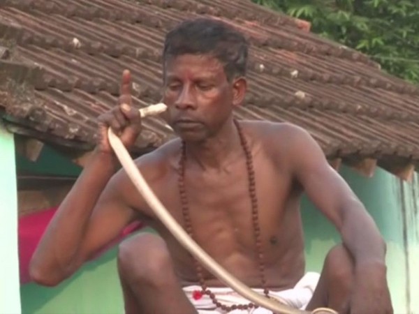 A snake biting a man during the ritual  in Jamshedpur's village in Jharkhand.