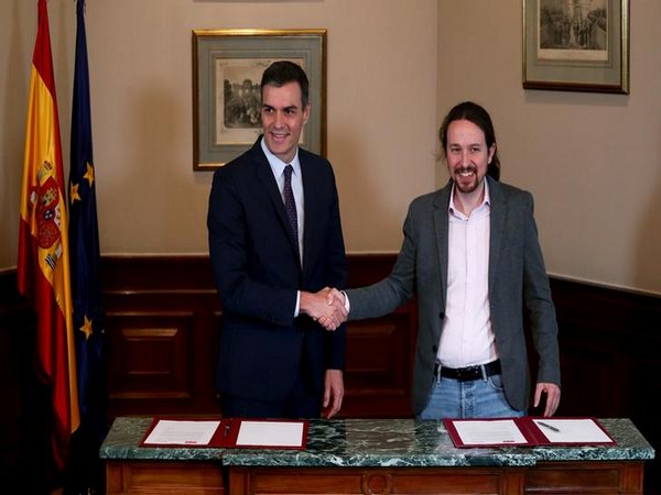 Spanish acting Prime Minister Pedro Sanchez and Unidas Podemos leader Pablo Iglesias shake hands during a news conference at Spain's Parliament in Madrid