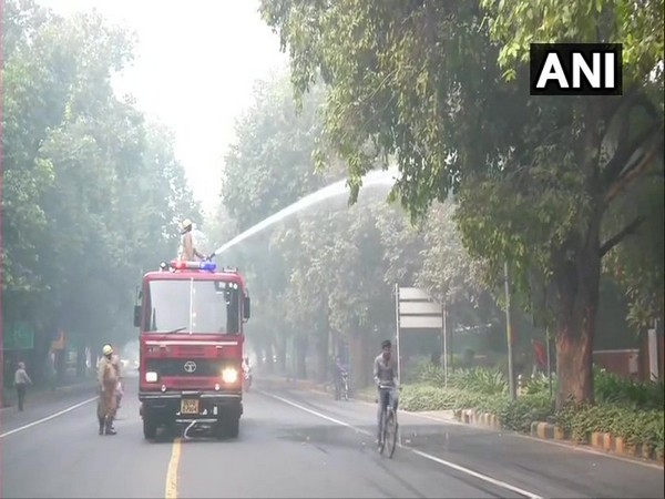 NDMC sprinkles water in the area around Feroz Shah Road to settle the dust, as a pollution control measure. [Photo/ANI]