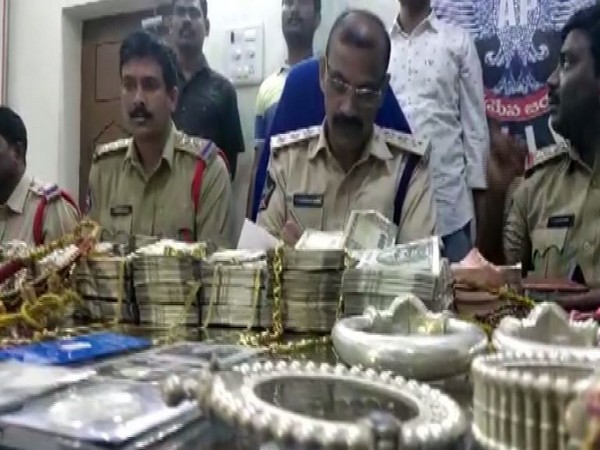 Andhra Pradesh police with the recovered cash and jewellery on Sunday.
