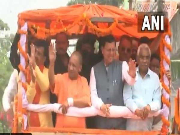 CM Pushkar Singh Dhami holds a roadshow along with UP CM Yogi Adityanath in Champawat. (Photo/ANI)