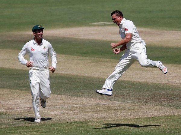 Australia's Steve O'Keefe (R) celebrates with team mates the wicket of India's skipper Virat Kohli