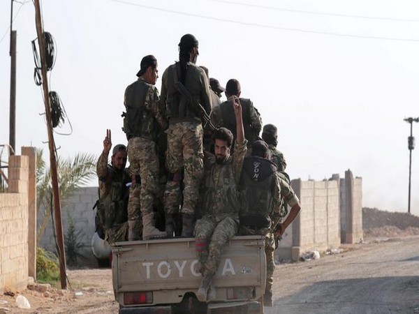 Turkey-backed Syrian rebel fighters enter the village of Yabisa, near the Turkish-Syrian border.