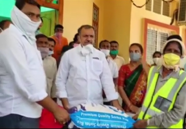 MLA Gandra Venkataramana Reddy distributing essential commodities to sanitation workers in Jayashankar Bhupalpally. 