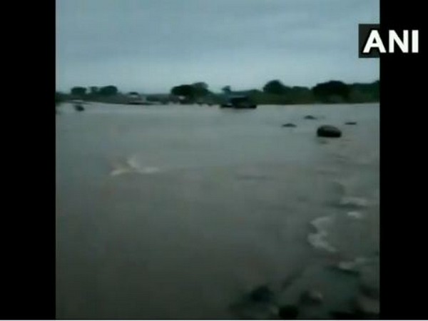 The tractor got swept away as it tried to cross the flooded bridge. Photo/ANI