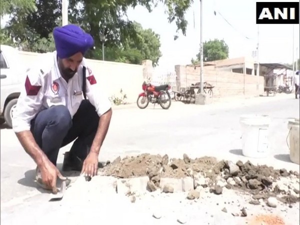 Traffic cop Gurbkhs Singh fills potholes on a Bhatinda road